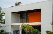 A image of the outside of a white and orange library in Oakland.