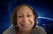 An African American woman is on a Zoom webinar with earth and outer space as the background.