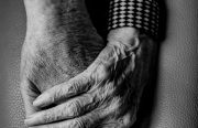 A black and white photo of older people holding hands.