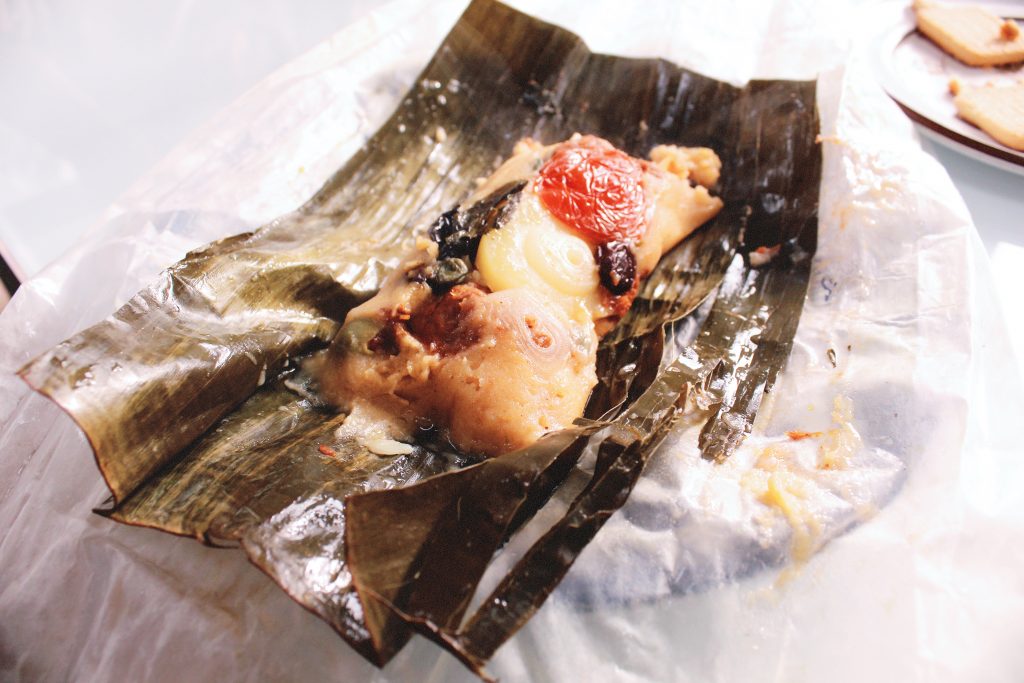 A leaf is open. What is inside? It looks like many ingredients that go inside a Nicaraguan tamale!