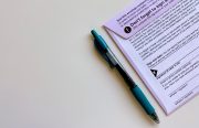 A mail in ballot next to a blue pen.